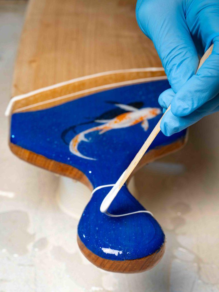 Peinture à la main sous résine bleue sur une planche en bois Peinture à la main sous résine bleue sur une planche en bois