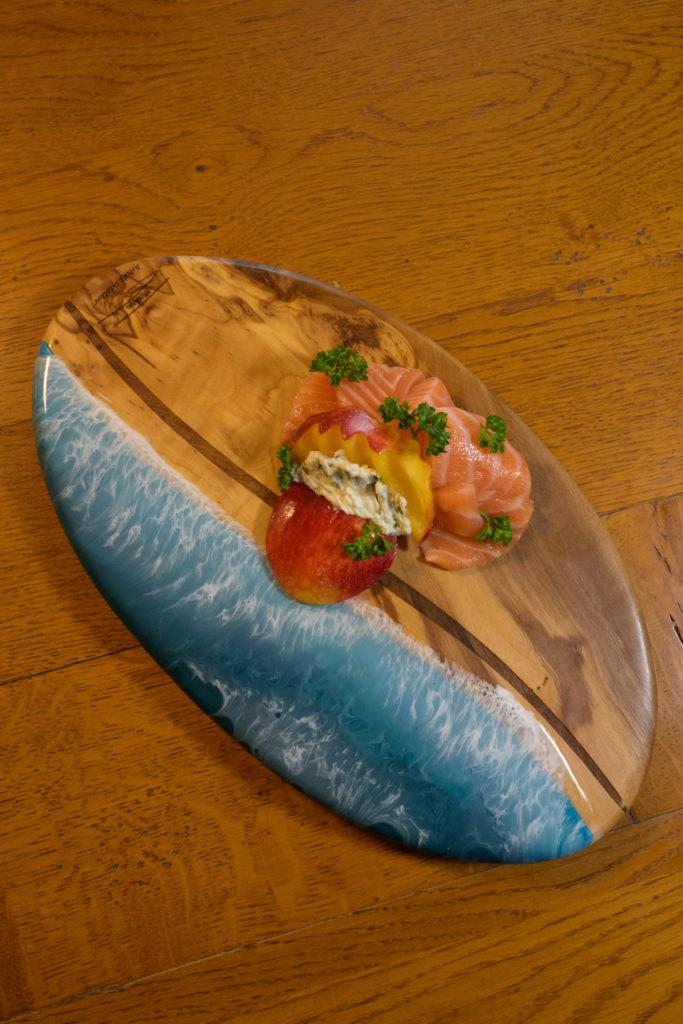 Saumon et salade sur planche ovale en bois et résine bleue Saumon et salade sur planche ovale en bois et résine bleue