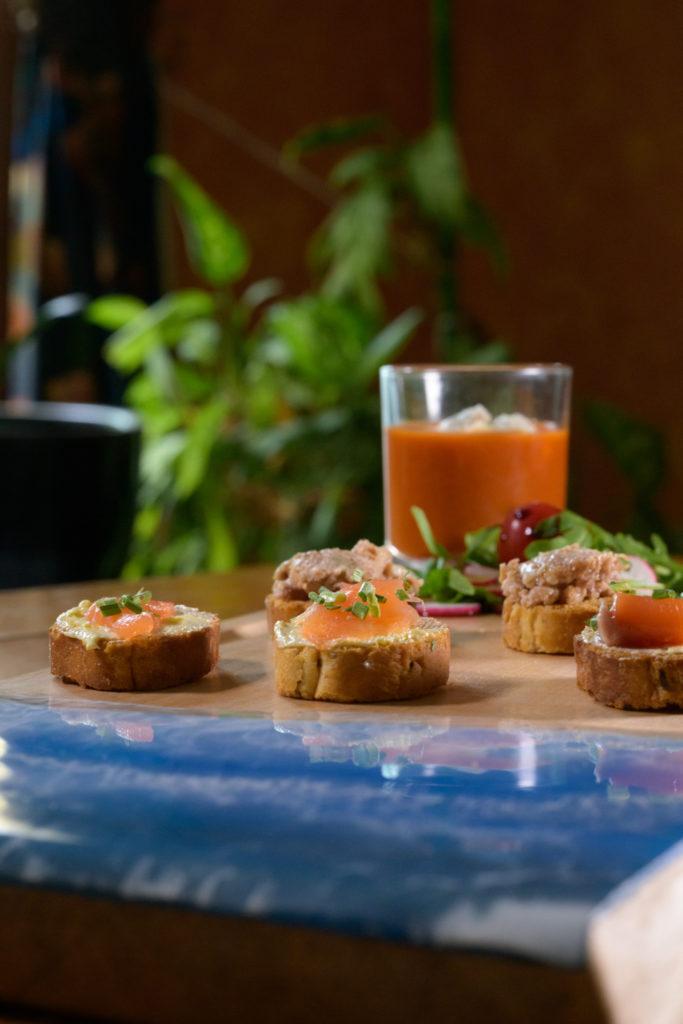 Toasts et verrine de gaspacho sur planche en bois et résine bleue Toasts et verrine de gaspacho sur planche en bois et résine bleue
