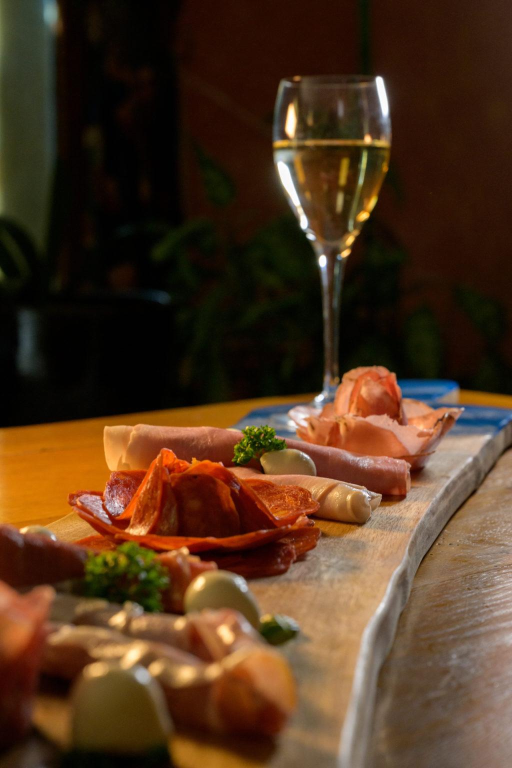 Planche de charcuterie en bois et résine bleue, verre de vin blanc